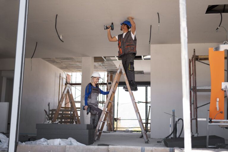 a man and a woman on a ladder to renovate the house